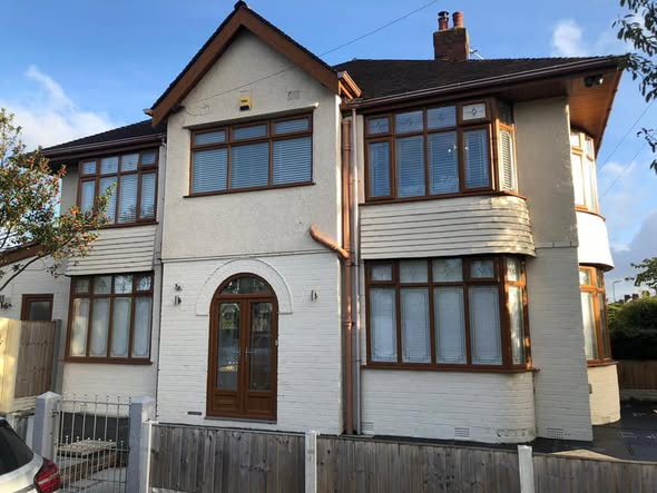 Semi-detached house front with old wood-framed windows and dated porch before RG renovation