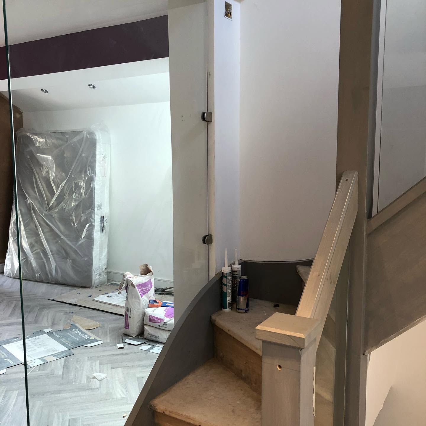 Bespoke timber staircase newel and treads under dust protection during install — RG joinery