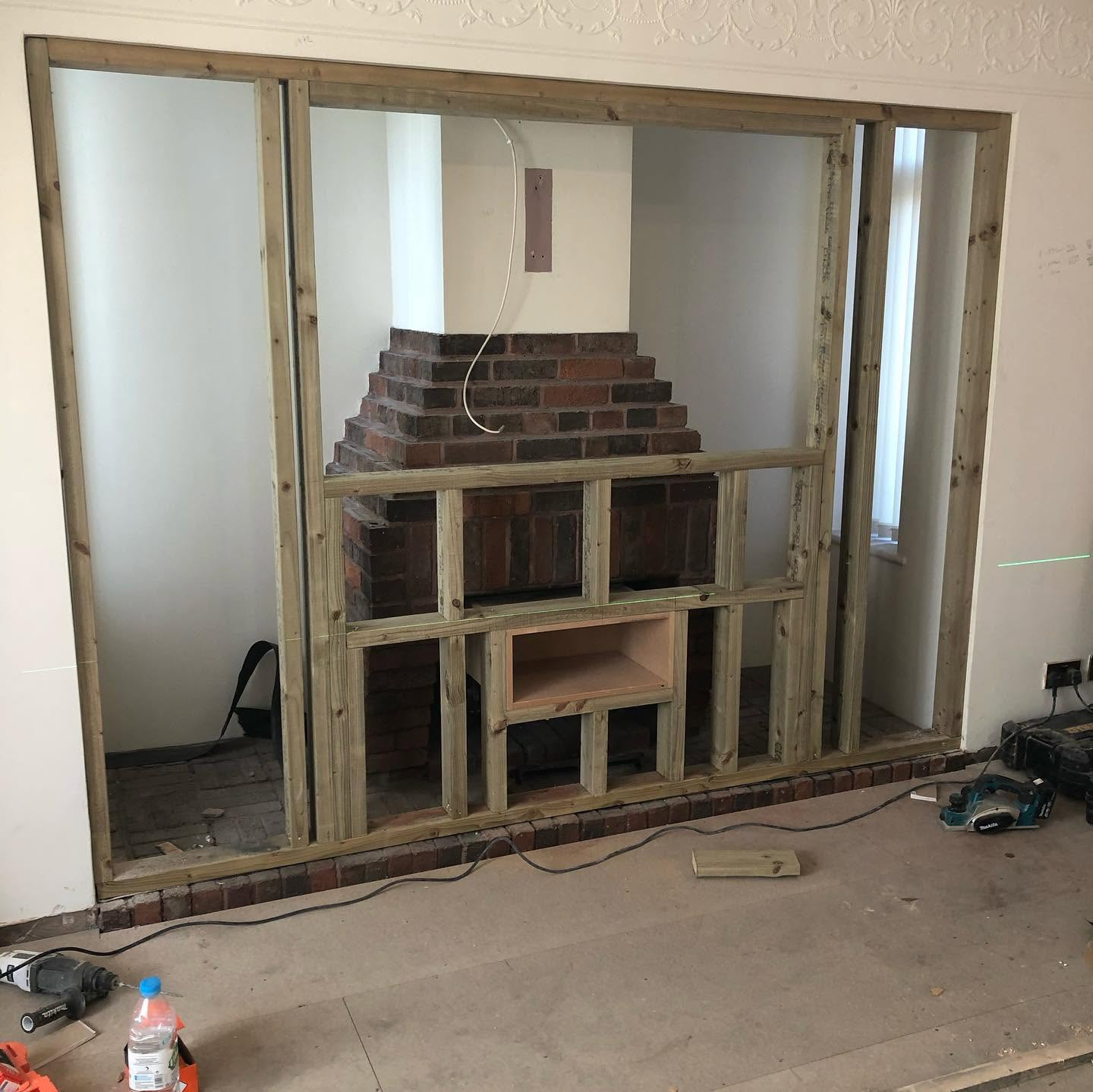 Original bare brick chimney breast in living room before RG media-wall build