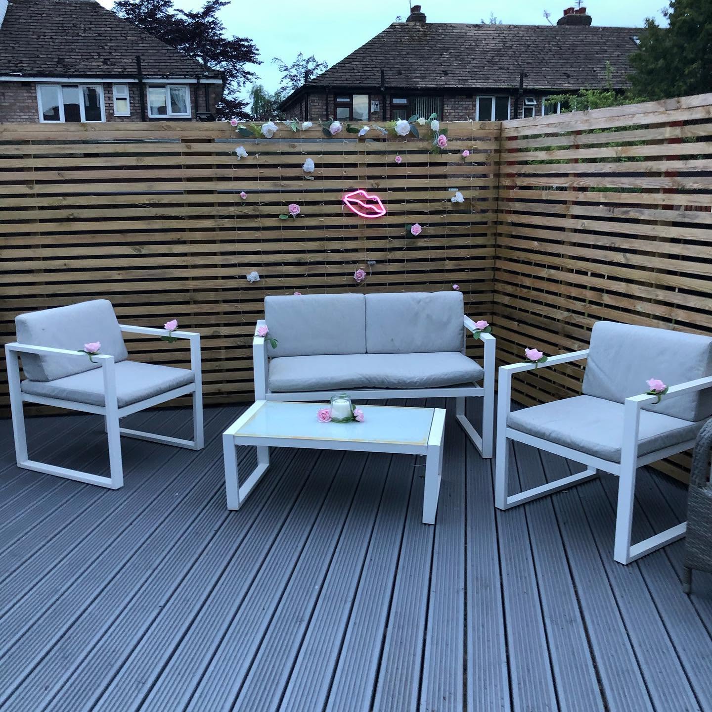 Garden lounge area with composite decking and slatted screens by RG