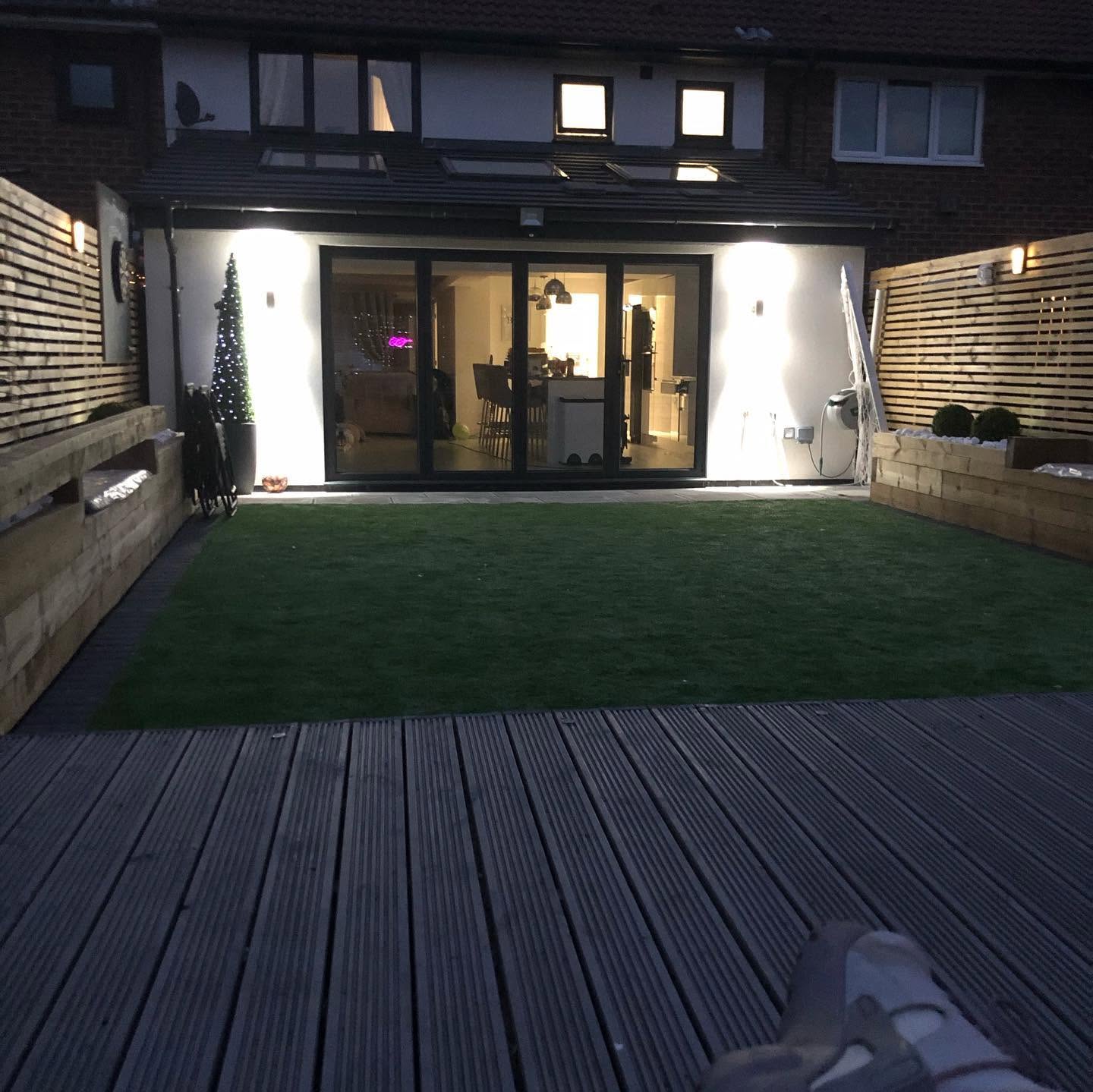 Completed rear extension lit at night with full-height glazing onto the garden